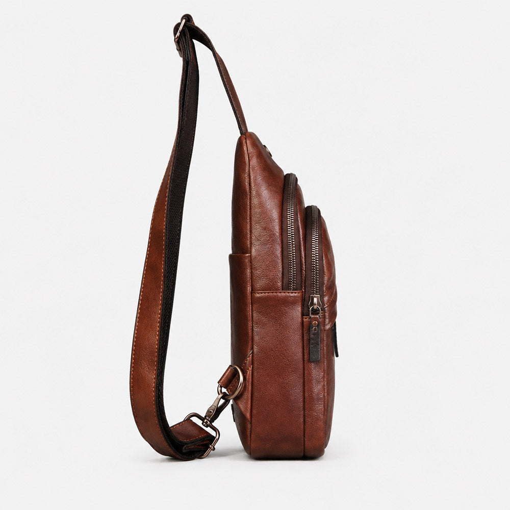 Front view of deep brown leather waist bag with leather logo patch, curved zipper structure, and vintage full-grain finish