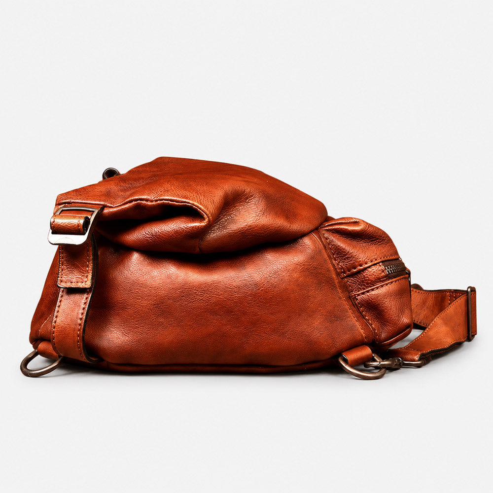 Bottom view of brown full-grain leather shoulder bag showing structured base, reinforced seams, and rugged waist pack construction