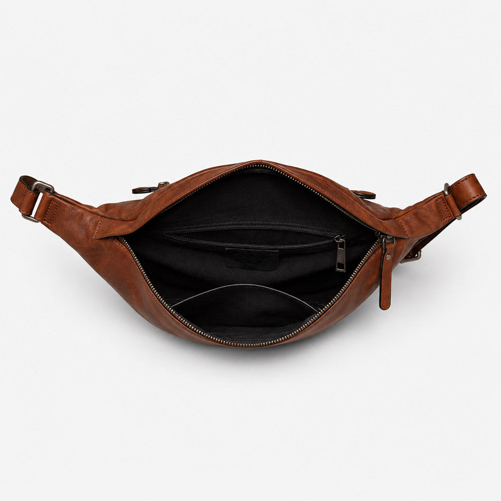 Open interior of large leather shoulder bag showing space for a 10-inch tablet, smartphone, wallet, passport, and power bank