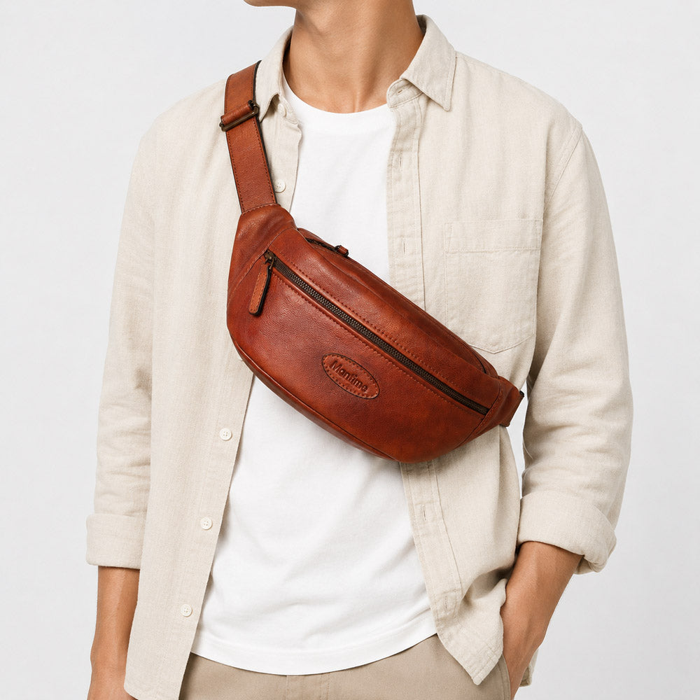 Brown mens leather waist bag worn as a crossbody sling on model, showing compact hands-free daily carry styling
