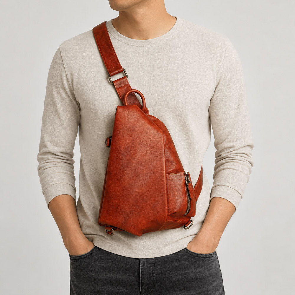 Brown leather shoulder bag worn crossbody on model, showing oversized hands-free carry for daily travel and creative gear