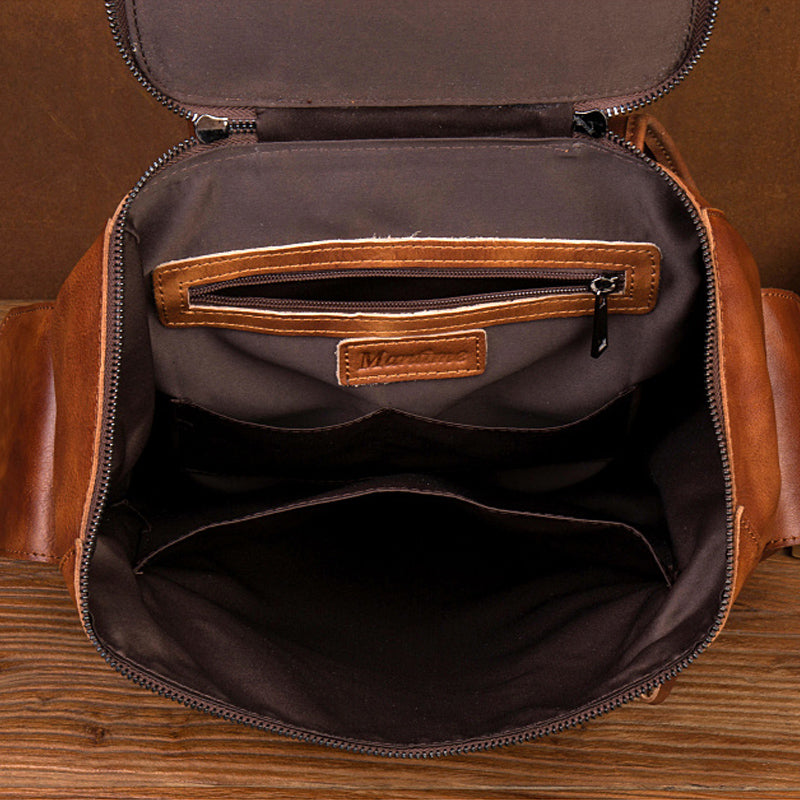 mens leather backpack features multiple storage compartments