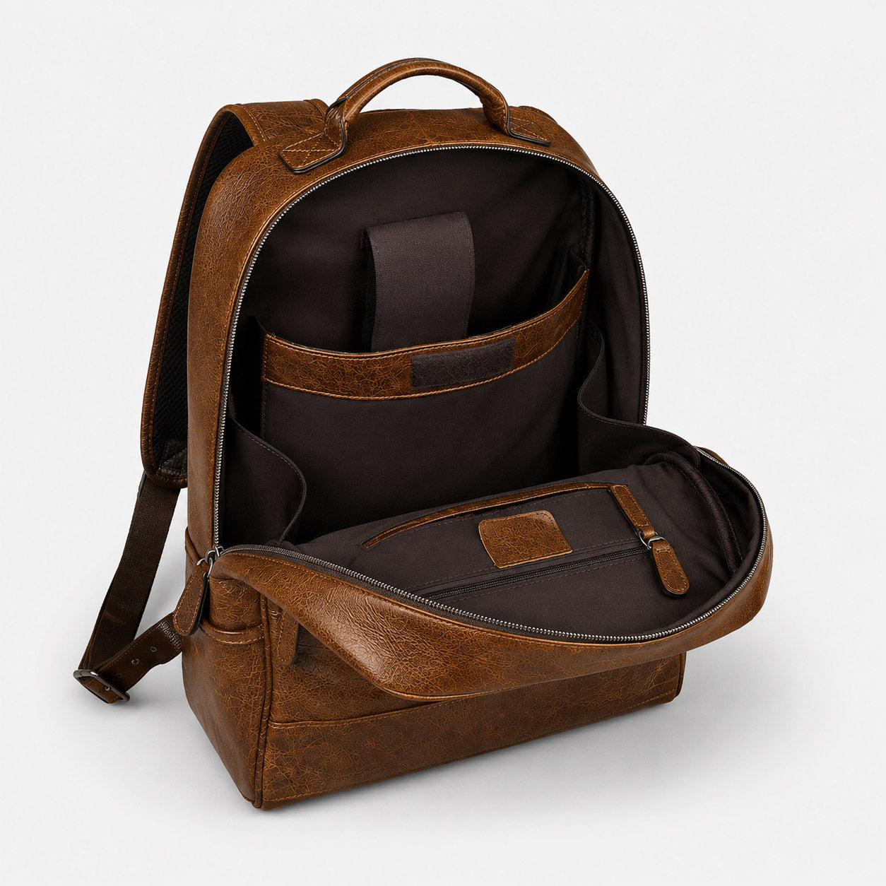 Leather backpack open showing 16-inch device compartment and internal dividers