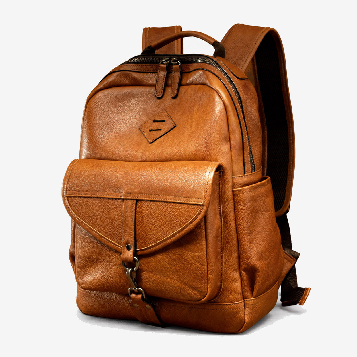 Vegetable-tanned leather backpack three-quarter view showing the box shape and side pocket