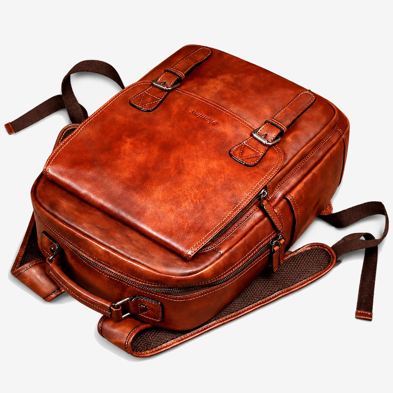 Top view of the leather backpack showing the buckled flap and mesh-backed straps