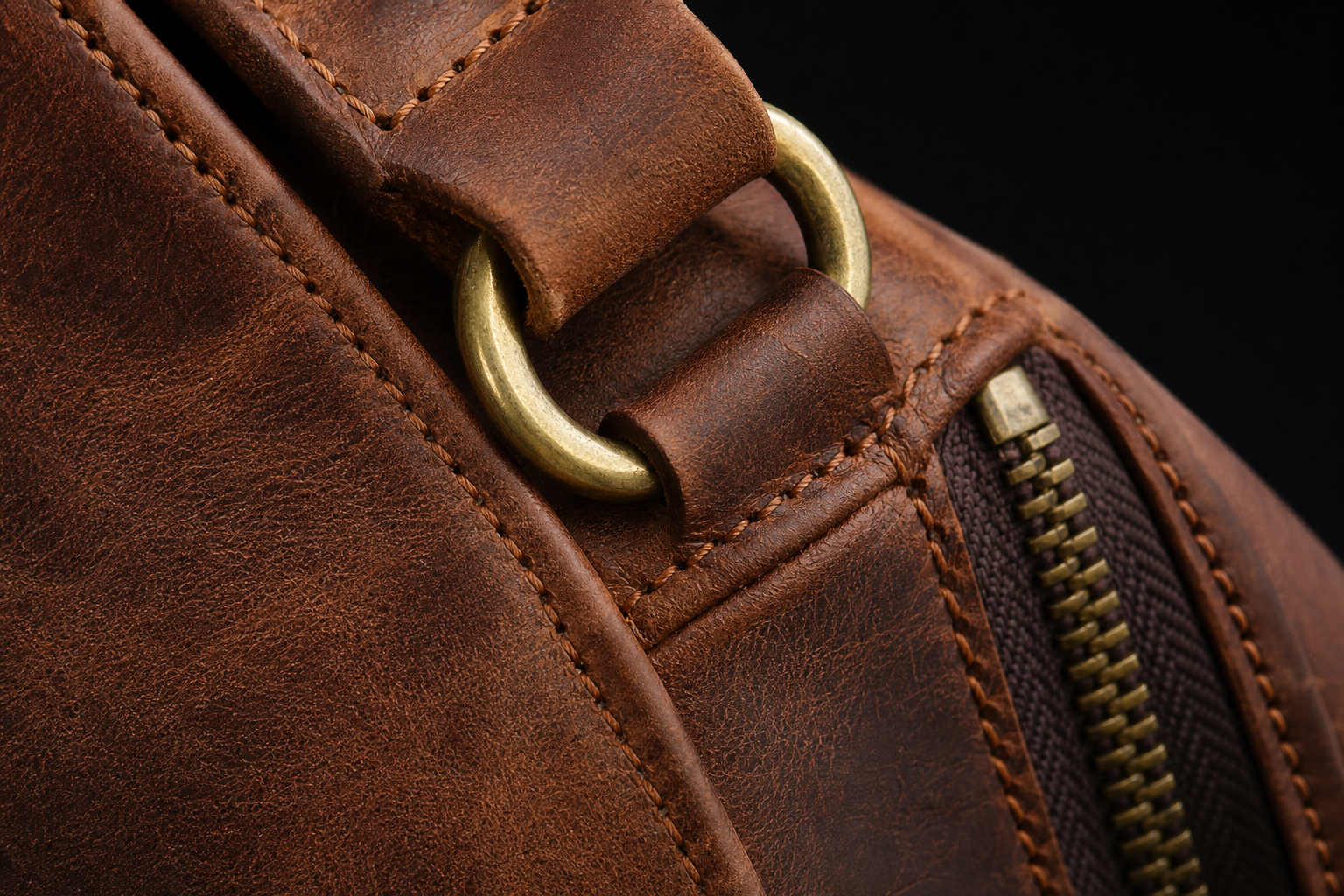 Macro view of brown leather grain stitching zipper and brass hardware